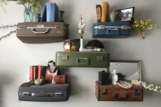 several suitcases are lined up on the wall with books and pictures hanging above them