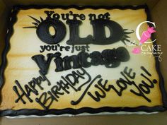 a birthday cake that is decorated with black icing and the words you're not old, you're just vintage happy birthday