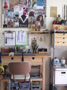 a desk with lots of crafting supplies on it and pictures hanging above the desk