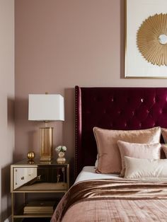 a bedroom with pink walls and gold accents