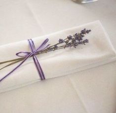 the napkin is wrapped in purple ribbon and tied with twine