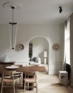 a living room filled with furniture next to a white couch and table on top of hard wood flooring