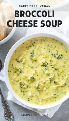 broccoli cheese soup in a white bowl with two spoons on the side