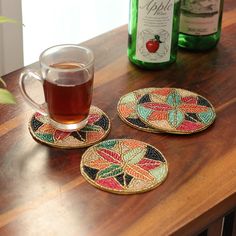 three coasters on a table with a cup of tea