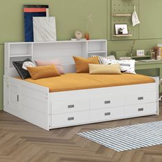 a white bed with drawers underneath it in a room