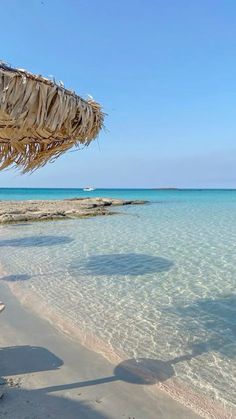 an umbrella on the beach with clear blue water