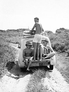 four people are sitting in the back of an old truck