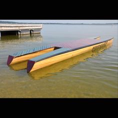 two canoes sitting in the water next to a dock