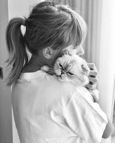 a woman holding a cat in her arms