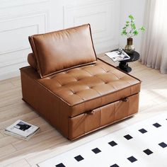 a brown leather couch sitting on top of a wooden floor next to a white rug