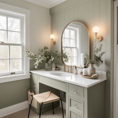 a bathroom with a vanity, mirror and stool next to a window in the room