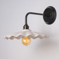 a light that is on the side of a wall with an umbrella shade over it