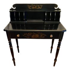 an antique black desk with drawers on it