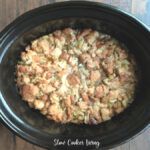 a crock pot filled with food on top of a wooden table