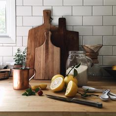 some lemons are sitting on a cutting board next to other kitchen utensils