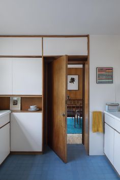 an open door leading to a kitchen with blue flooring