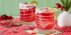 two glasses filled with cranberry margaritas sitting on top of a red and white table