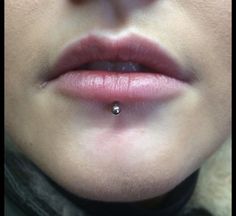 a woman with a nose piercing on her lip