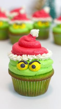 green cupcakes with red frosting and santa hats