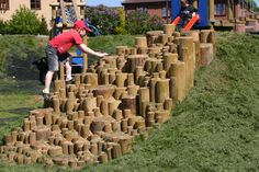 two children playing on a playground made out of clay blocks and bricks in the grass