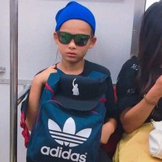 a little boy with sunglasses and a backpack