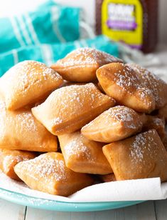 a pile of powdered sugar pastries sitting on top of a blue and white plate