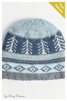 a blue and white knitted hat with trees on the front, against a white background