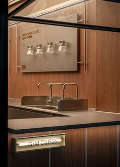 a kitchen with stainless steel sink and counter top in front of a sign that reads grid office