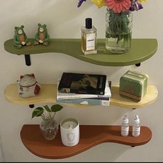 two shelves with books, vases and flowers on them