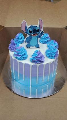 a blue and white cake in a box with an image of stitching stitch on it