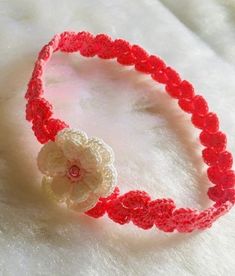 a crocheted headband with a flower on it sitting on a white surface