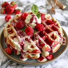 a waffle topped with raspberries and whipped cream sits on a marble table