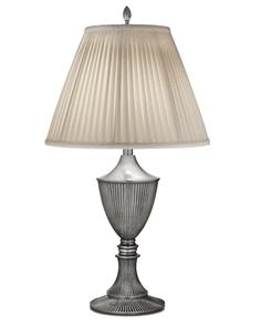 a silver lamp with a white shade on it's base and a beige lampshade