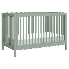 a green crib with white sheets on the bottom and side rails, against a white background