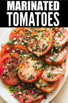 a white plate topped with sliced tomatoes and herbs