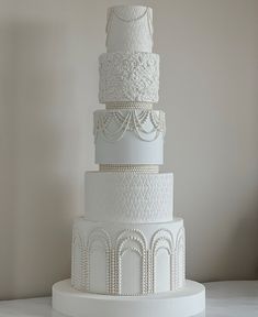 a three tiered white wedding cake sitting on top of a table