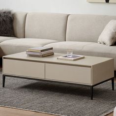 a coffee table sitting on top of a rug next to a couch