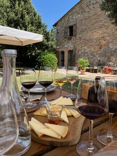 several glasses of wine and cheese on a wooden table