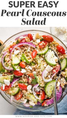 a salad with cucumbers, onions and tomatoes in a glass bowl on top of a table