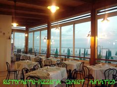 an empty restaurant with tables and chairs overlooking the ocean