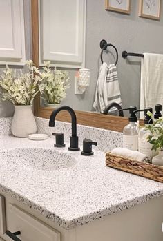 a bathroom sink with two faucets and soap dispensers