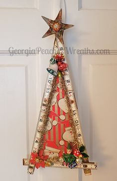 a christmas tree made out of rulers and other items hanging on a door handle with a star