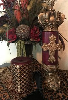 two vases with flowers in them sitting on a leopard print table cloth next to each other