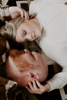 a man and woman laying on the floor next to each other with their eyes closed