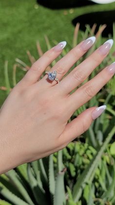 a woman's hand with white manies and a ring on her left hand