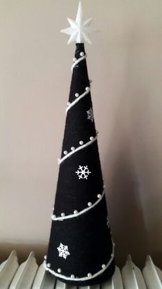 a black and white christmas tree sitting on top of a radiator heater