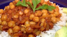 a blue plate topped with rice and chickpeas next to avocado wedges