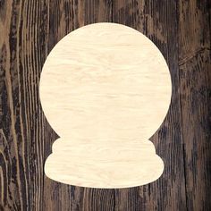 an unfinished wooden object sitting on top of a wood floor next to a black and white wall