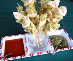 a vase filled with flowers sitting on top of a tray next to dipping sauces