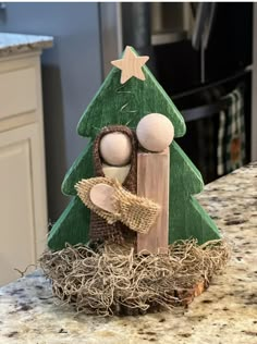 a wooden christmas tree with two dolls in it